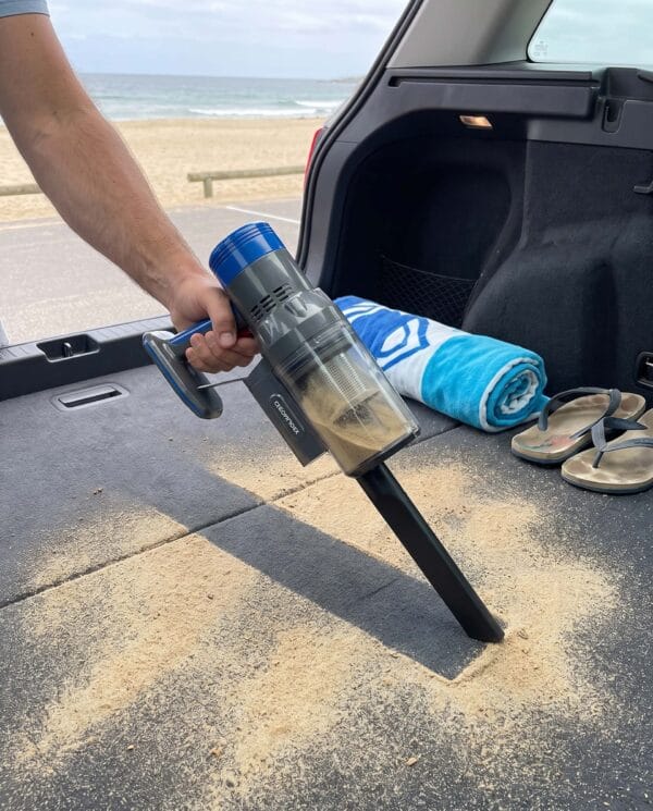 Σκούπα χειρός CleanMaxx μαζεύει άμμο παραλίας από το πορτ-μπαγκάζ αυτοκινήτου